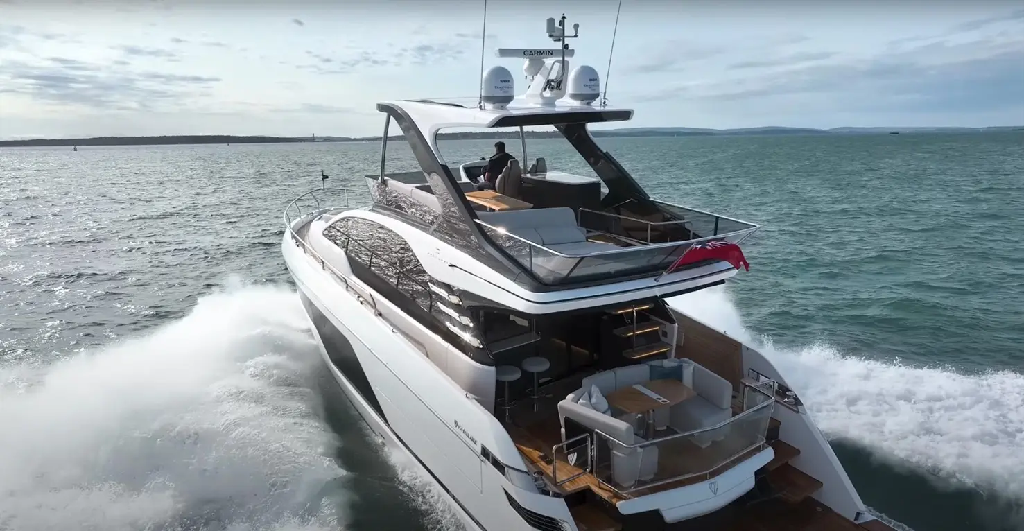 Luxury yacht cruising on water with a captain at the helm, featuring outdoor seating and a sleek modern design.